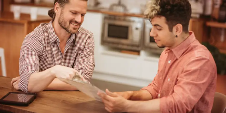 Two people at a table examining paperwork, illustrating maintenance and repair discussions.