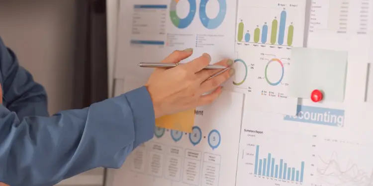 Someone pointing at charts and pie graphs illustrating budget expense breakdown.