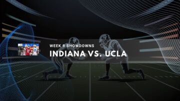 Two football players face off on a stadium field under bright lights