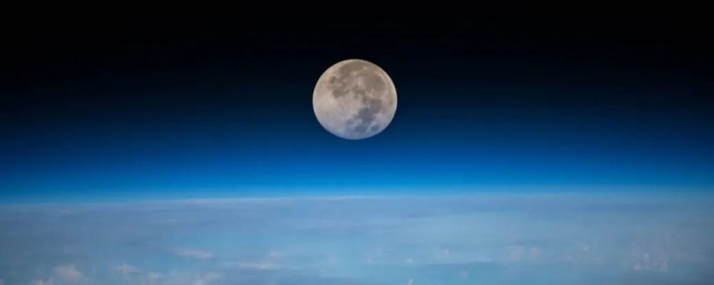 A close up of the moon with the Earth below